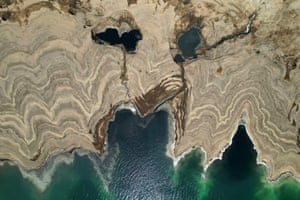 Dead Sea, Israel An aerial picture shows patterns formed by crystalised minerals and sinkholes on the surface of a dried-up area of the Dead Sea near the southern Israeli Neve Zohar resort. The Dead Sea has lost a third of its surface area since 1960, with the blue water receding about a metre every year, leaving behind a lunar landscape whitened by salt and perforated with gaping holes