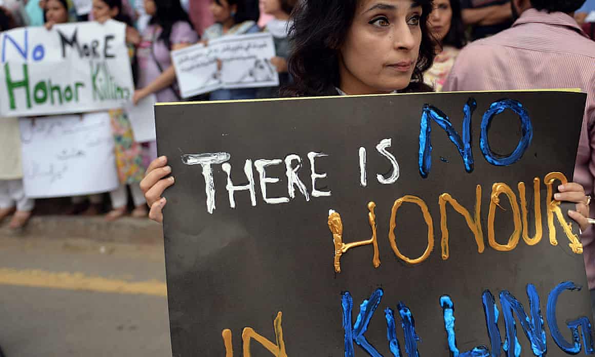 A woman holds a large sign reading “there is no honour in killing” at during a protest in Islamabad