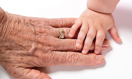 Baby's hand touching older woman's hand