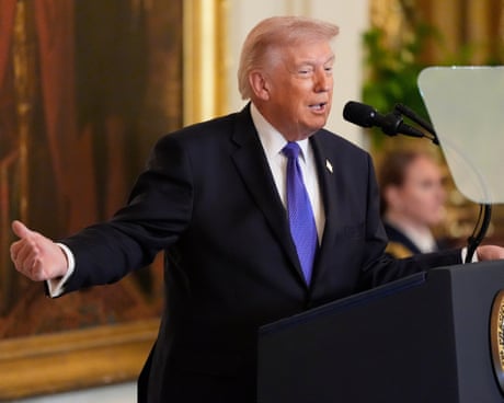 a man in a suit speaks into a microphone