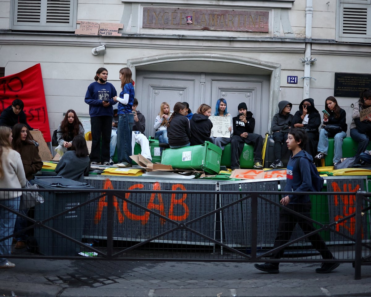 French high school students sit on barricades outside the Lycee Lamartine high school in Paris.