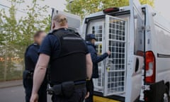 Immigration officers next to a custody van