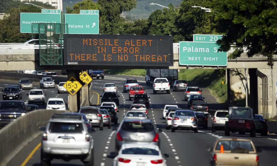 Cars drive past a highway sign that says ‘Missile alert error: there is no threat’ on the H1 freeway in Honolulu.