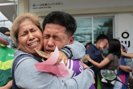 A student reacts with a relative after being evacuated from the Debsirin Nonthaburi School.
