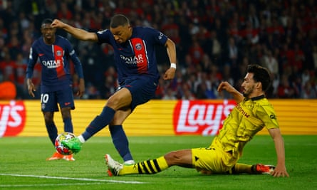 Kylian Mbappé attempts a shot while being challenged by Mats Hummels.