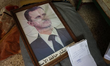 A portrait of Bashar al-Assad is pictured with its frame broken, in a political security branch facility of the Syrian regime on the outskirts of the central city of Hama.