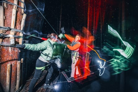 Two adults high-five on a high ropes course in the trees