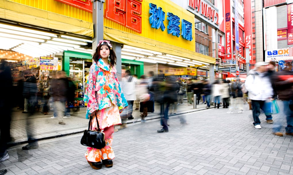 Young woman standing in front of electric department store japan