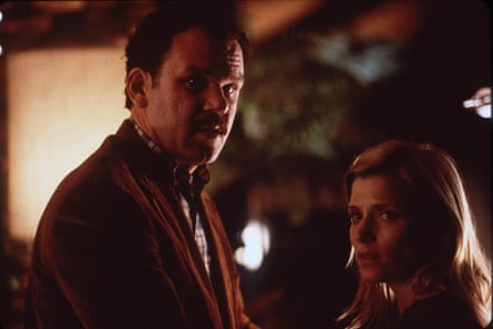 John C Reilly and Melora Walters looks pensively at the camera