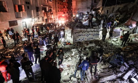 Residents and civil defense teams carry out search and rescue under the rubble after an Israeli attack on a building in Khan Younis, Gaza