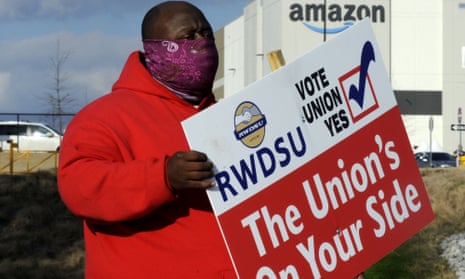 Michael Foster of the Retail, Wholesale and Department Store Union holds a sign outside an Amazon warehouse where the union is trying to organise workers