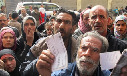 Displaced people from the Yarmouk Palestinian refugee camp queue to receive aid in Yalda, south of Damascus on 16 April 2015.