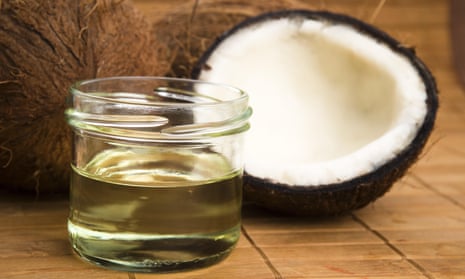 A cracked coconut and a jar of oil