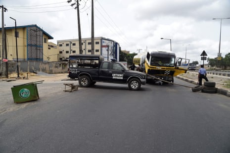 Policemen mount a road block with a stick to prevent the movement of motorists around Lagos on Tuesday