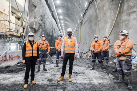 Dan Andrews posing with construction workers in a half-completed railway tunnel