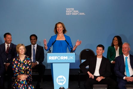 Sarah Pochin speaking and gesticulating with both hands behind a lectern