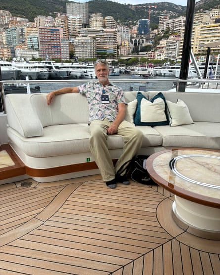 Sam Wollaston sits on a sofa on the deck of a superyacht.