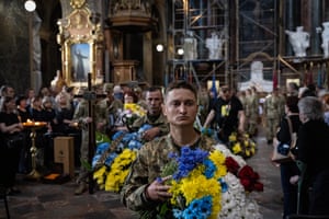 Lviv, Ukraine: A soldier carries flowers in the national colours, as the Ukrainian Army buries three of its soldiers with military honours, in the Saints Peter and Paul Garrison Church