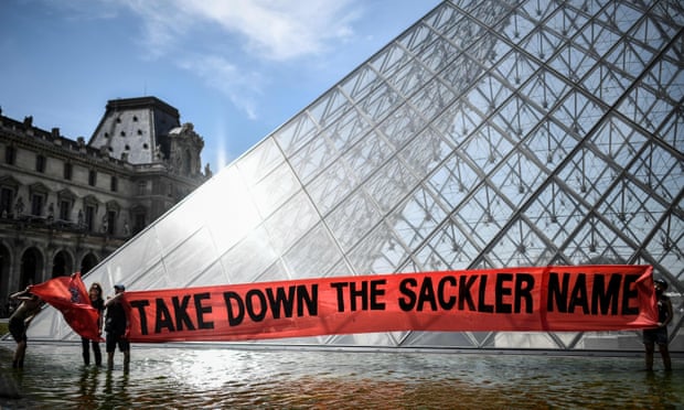 Activists of Pain (Prescription Addiction Intervention Now) holding a banner reading ‘take down the Sackler name’ in front of the Louvre museum.