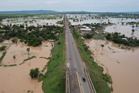 A road and some tress are visible rising above a landscape flooded with water