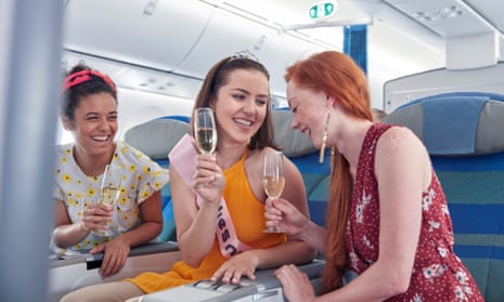 Young women drink champagne on an aeroplane
