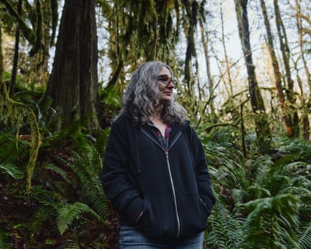 A woman standing amid trees and lush green plants