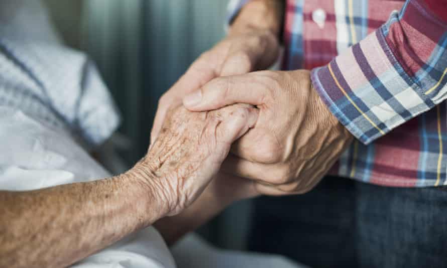 A senior man’s hand being held