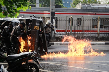 Police officers are targeted with a molotov cocktail during a demonstration demanding the dissolution of parliament on a street near the House of Representatives building in Jakarta on 25 August 2025.