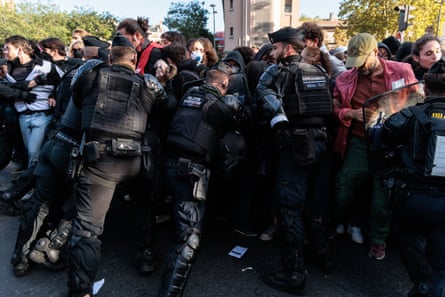 Riot police push against a crowd of protesters