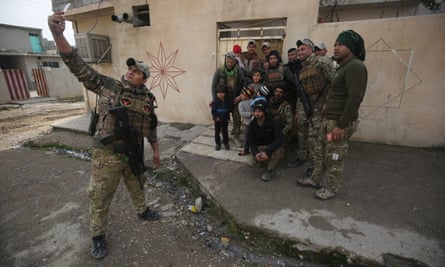 Members of the Iraqi forces pose for a photograph as troops advanced in Mosul’s eastern Al-Intisar neighbourhood in 2016.