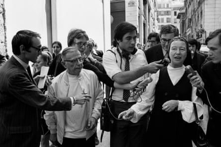 De Beauvoir and Sarte on a Paris street after their release from police custody. They were arrested for selling a newspaper advocating the overthrow of the French government.
