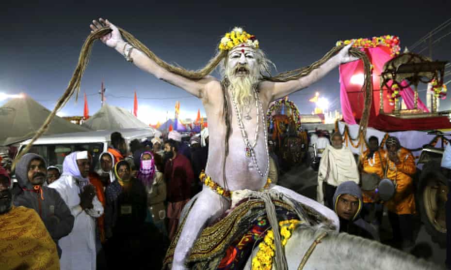 A naked Hindu holy man arrives on a horse back for ritualistic dip on auspicious Makar Sankranti day during the Kumbh Mela