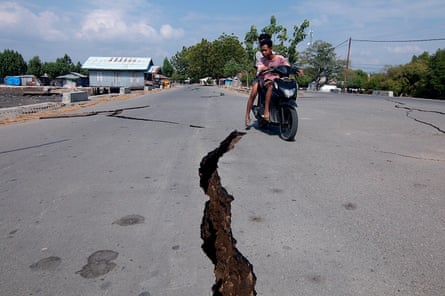 A motorcyclist rides past a crack on the road in Mbay, Nagekeo, East Nusa Tenggara province.