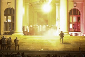 Protesters thrown flares at riot police on the steps of the parliament building in Belgrade.