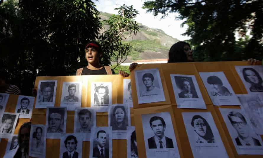 A man holds a placard with pictures of the victims of Brazil’s military dictatorship at a 2012 protest in Rio de Janeiro.