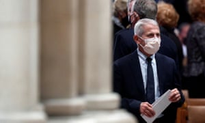 Anthony Fauci at Washington National Cathedral earlier this month – Fauci is seen in a white face mask carrying some documents next to a stone column in Washington, DC.