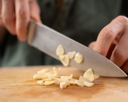 Close-up of a chef slicing garlic cloves