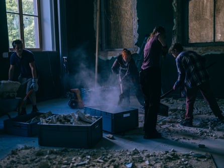 Four people clean debris at a gallery in Ukraine