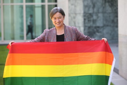 Penny Wong carries the rainbow flag in celebration.
