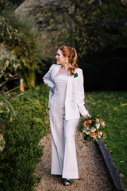 Woman in white suit holding bunch of flowers