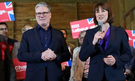 Keir Starmer with Rachel Reeves holding a microphone, with people brandishing Vote Labour signs in the background