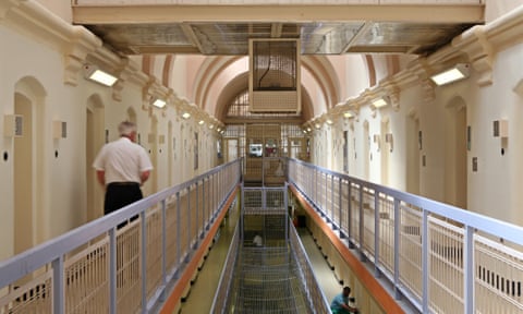 A prison officer walks down the C wing at Wandsworth prison - a Victorian prison with white calls