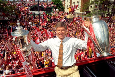 Arsène Wenger poses with the Premier League trophy and FA Cup outside Islington Town Hall.