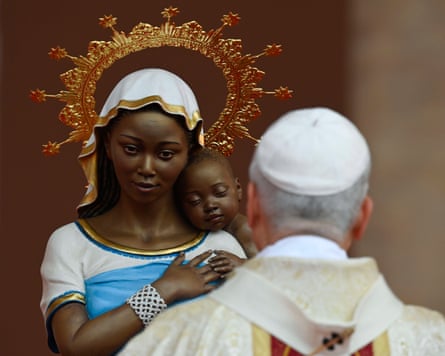 The pope facing a statue of a woman and a baby with a gold halo around them