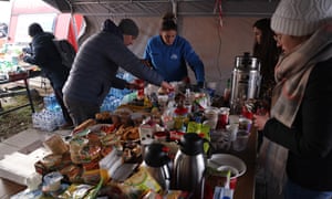 Local volunteers offer food and tea to people fleeing Ukraine at a border crossing to Ukraine on March 1, 2022 near Hrebenne, Poland.