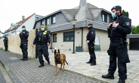 A sniffer dog leaves a home after a police raid in Leverkusen, Germany, in June 2021.