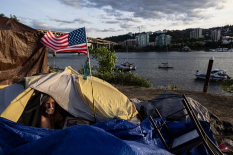 A man in a tent with an American flag next to a river