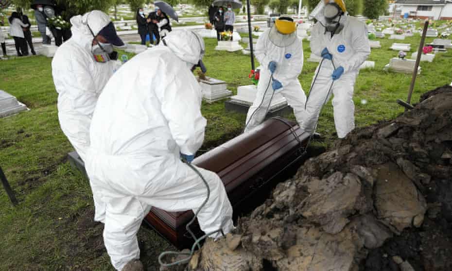 Cemetery and funeral workers lift a coffin containing the remains of a man who died of Covid-19, at Park Cemetery in Zipaquira on Friday.