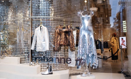 A blazer, faux fur coat and silver dress in the window.
