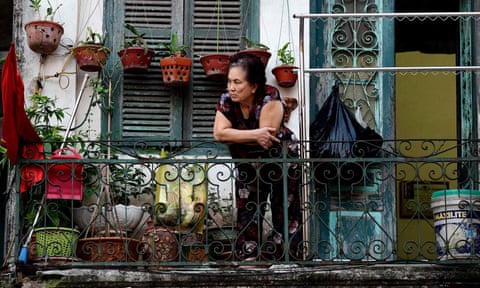A resident looks out from the balcony of her home in Hanoi.